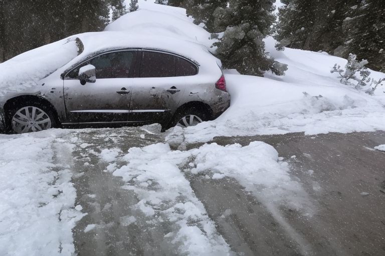 A car stuck in a ditch after skidding off an icy road during a massive Tahoe snowstorm that closed I-80 yesterday