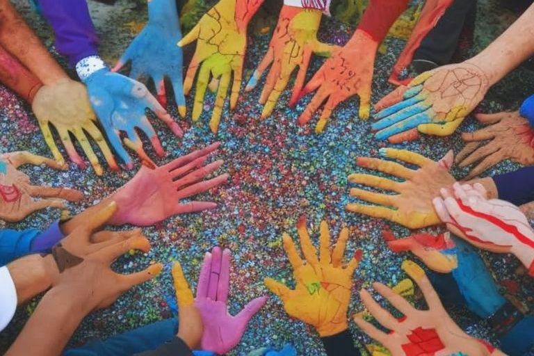 A map of Turkey surrounded by colorful hands representing different nationalities reaching out in solidarity