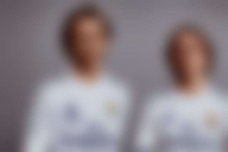 A picture of Luka Modric with Jude Bellingham standing side by side wearing Real Madrid kits (with both names printed on them).